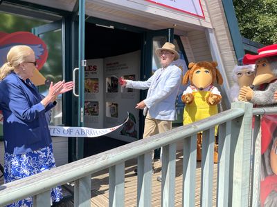 Marcus Robertson cuts the ribbon, wtih Vanessa Pugh and the Wombles clapping
